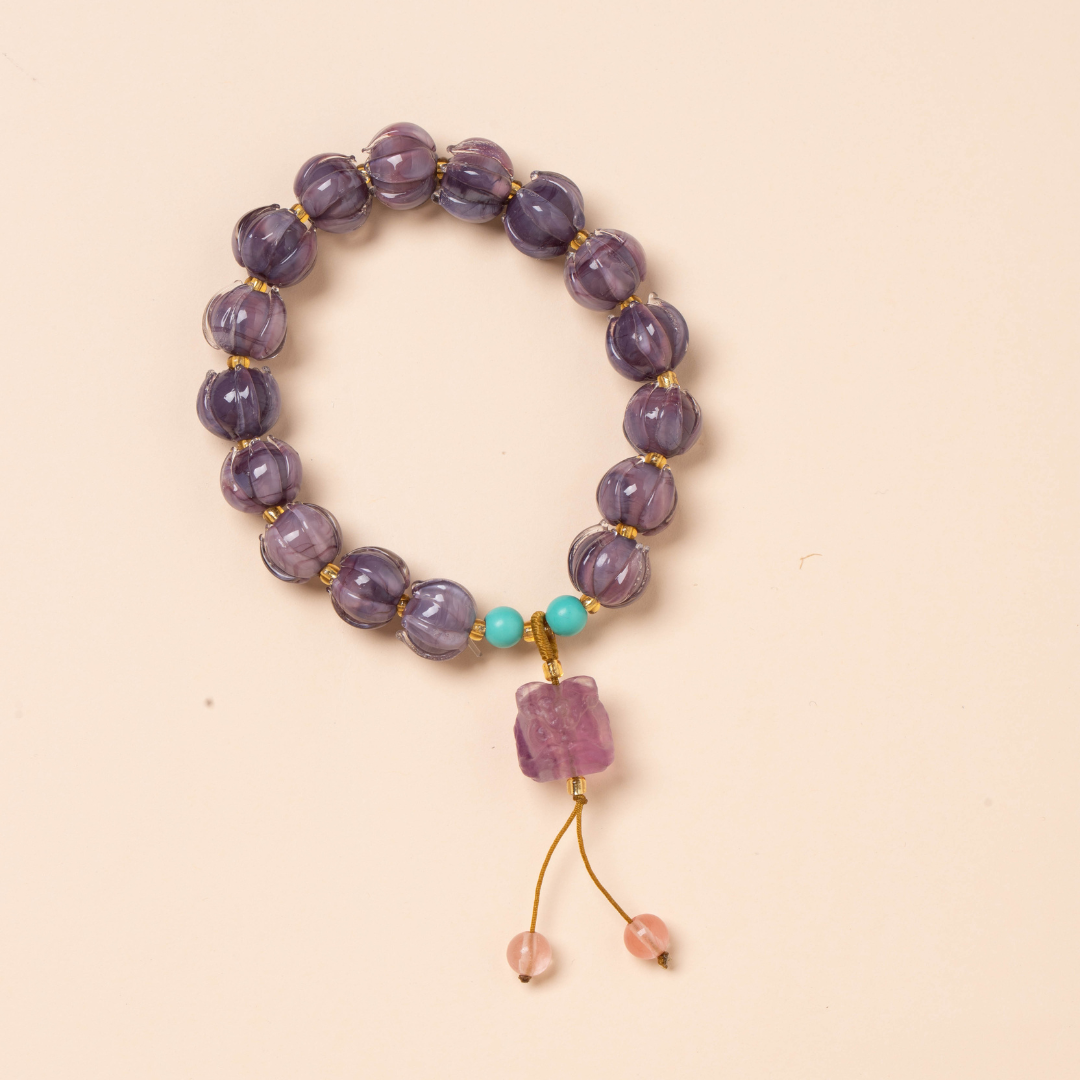 I braccialetti in vetro smaltato viola raffigurano un fiore di loto che simboleggia la "buona fortuna" ed è pieno di energia positiva.